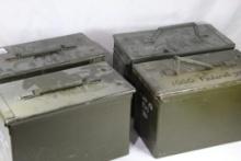 Four green metal 50 cal ammo boxes.