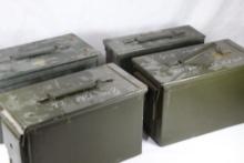 Three 50 cal and one 30 cal green metal ammo boxes.