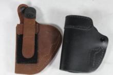 Two leather left handed belt clip holsters.