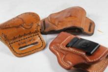 Three small leather right handed holsters.