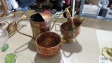 Copper colored watering can, bucket, and other decorations