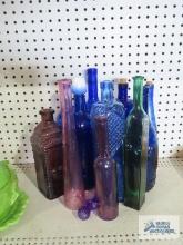 Blue glass, pink glass, and green glass bottles