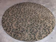 (BASE) LARGE CIRCULAR AREA RUG WITH DARK GREEN AND GOLD DAMASK PATTERN. THIS ELEGANT RUG FEATURES A