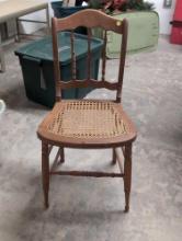 (BASE) ANTIQUE WOODEN CHAIR WITH TURNED SPINDLES AND WOVEN CANE SEAT. DOES NEED A LITTLE REPAIR TO