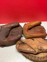 three vintage baseball gloves