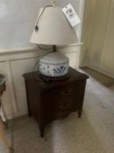 dark French provincial nightstand and antique lamp